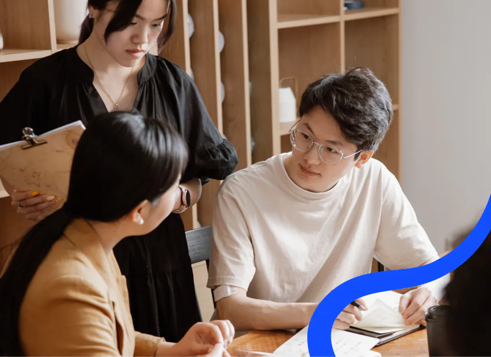 Three colleagues talking through the numbers together at a table