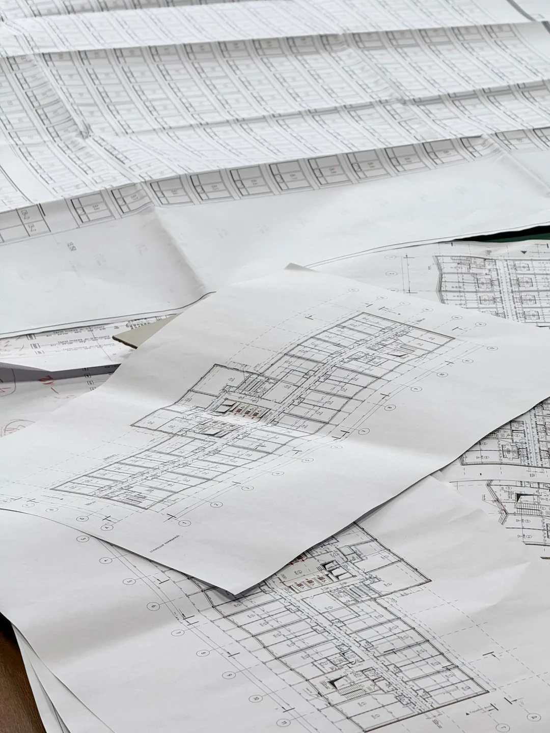 Construction floor plans and drawings spread across a table
