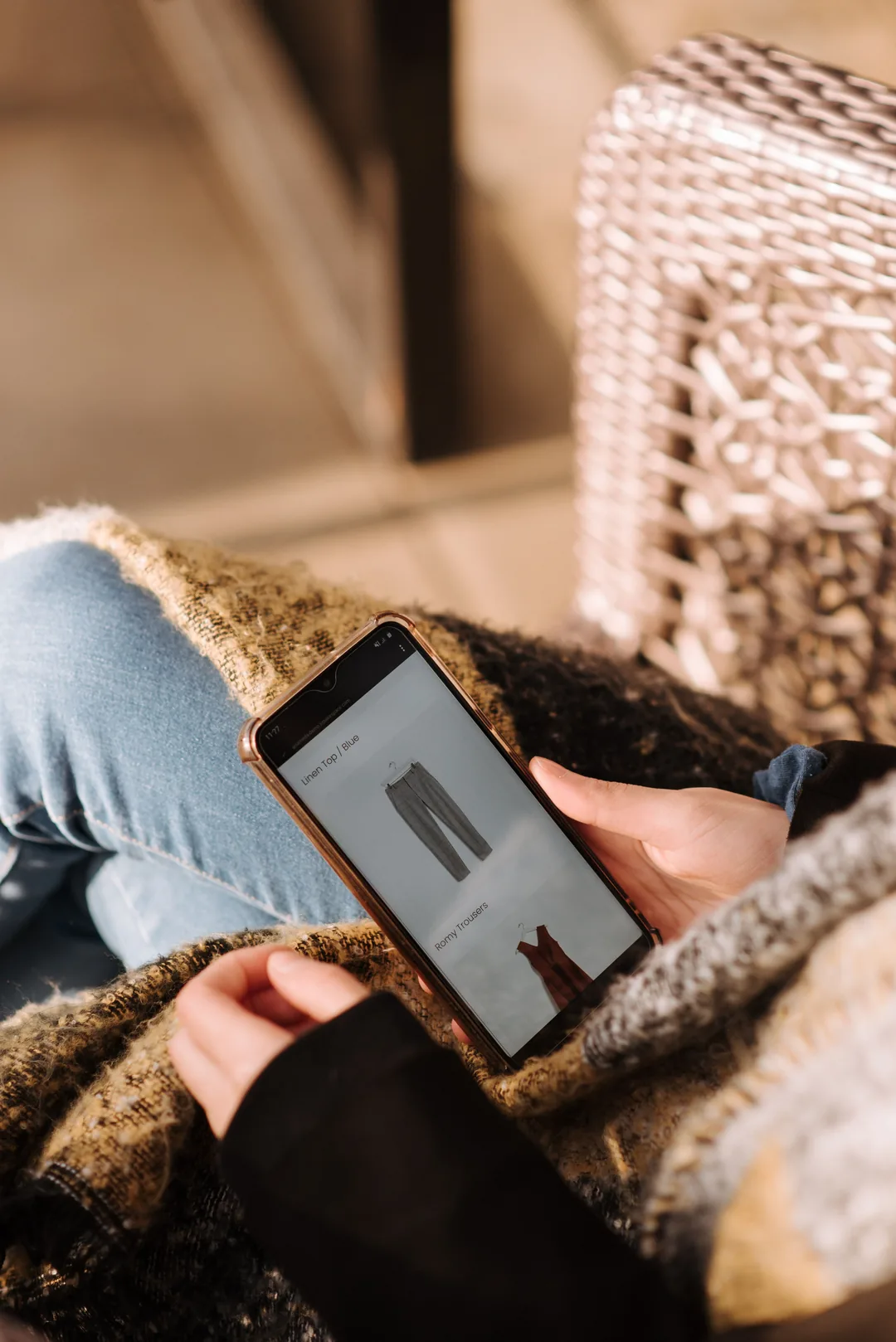 Someone browsing a clothing shop on their phone at home